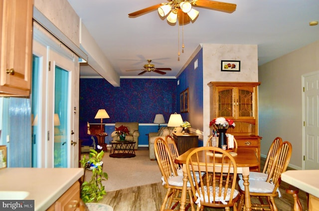 dining space featuring ceiling fan, crown molding, beamed ceiling, and wood-type flooring