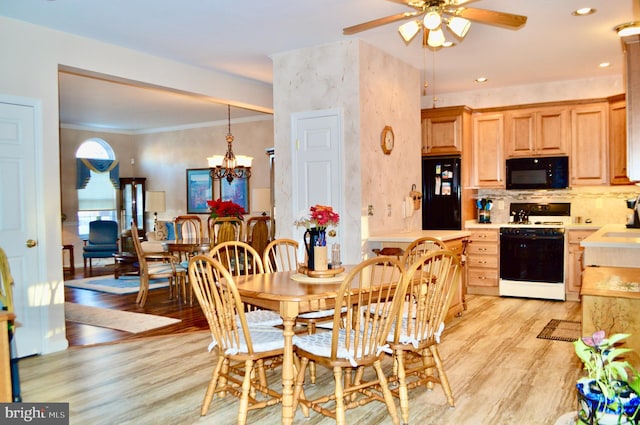 dining space featuring ceiling fan with notable chandelier, sink, light wood-type flooring, and ornamental molding