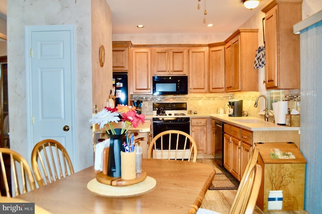 kitchen with decorative backsplash, light brown cabinetry, sink, and black appliances