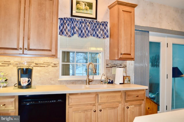 kitchen featuring light brown cabinets, black dishwasher, backsplash, and sink