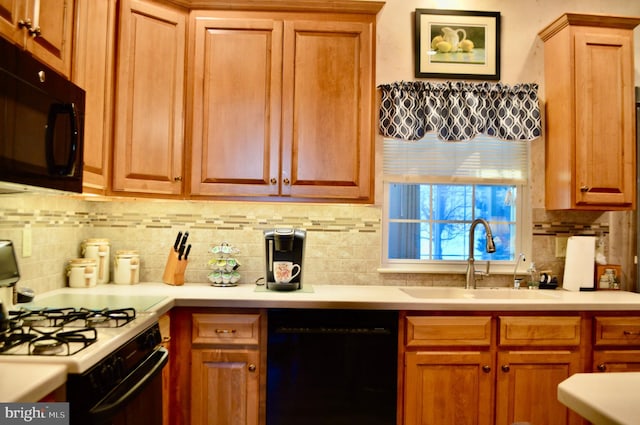 kitchen with black appliances, decorative backsplash, and sink