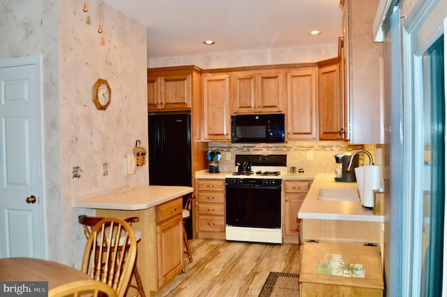 kitchen featuring decorative backsplash, sink, light hardwood / wood-style floors, and white stove