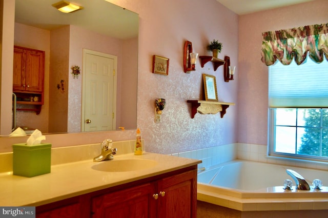 bathroom featuring vanity and a relaxing tiled tub