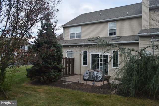 back of property with a patio area and a yard