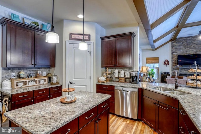 kitchen with decorative light fixtures, light stone countertops, a center island, and dishwasher