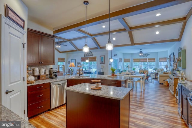 kitchen with a center island, a wealth of natural light, light stone countertops, decorative light fixtures, and stainless steel dishwasher