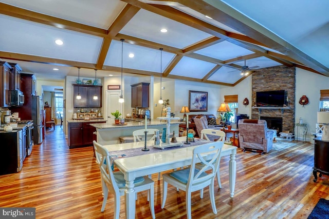 dining area featuring lofted ceiling with beams, plenty of natural light, and light hardwood / wood-style floors