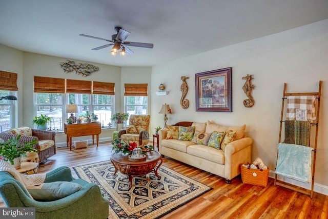 living room featuring wood-type flooring and ceiling fan