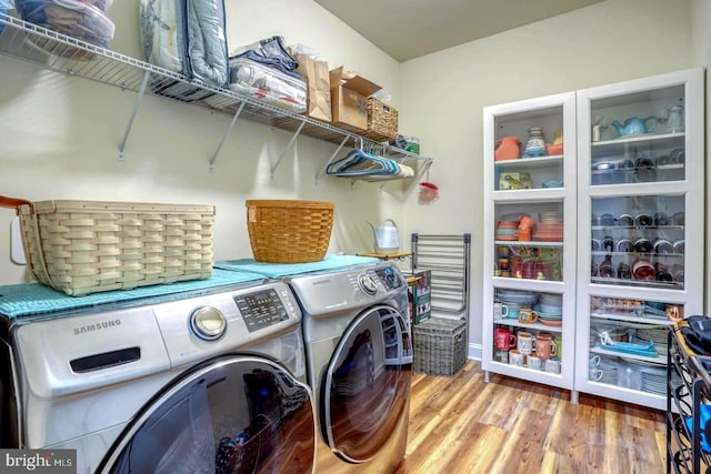 laundry area with hardwood / wood-style floors and washer and dryer