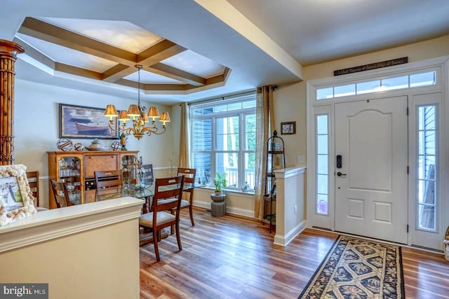 entrance foyer featuring beam ceiling, coffered ceiling, hardwood / wood-style floors, and an inviting chandelier