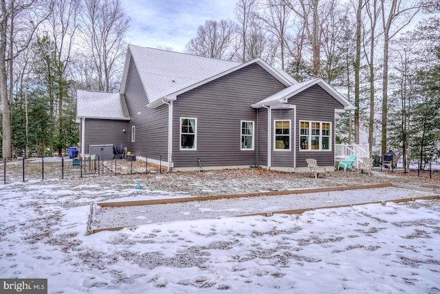 view of snow covered rear of property