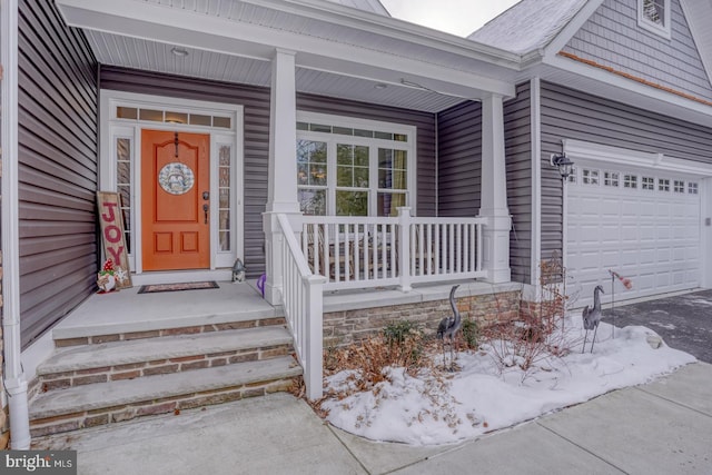 view of exterior entry featuring a garage and a porch