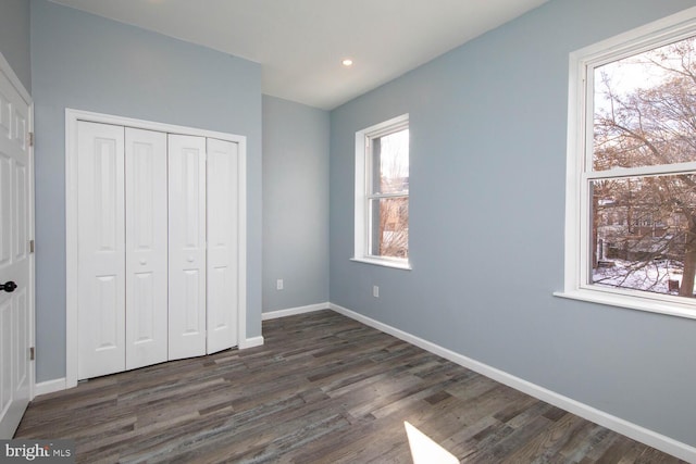 unfurnished bedroom featuring dark hardwood / wood-style floors and a closet