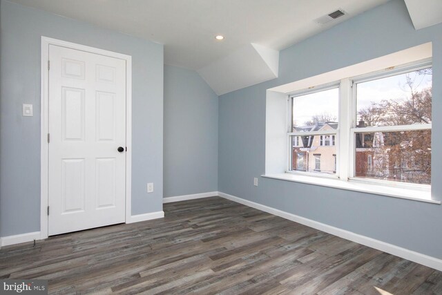 additional living space featuring dark wood-type flooring and lofted ceiling