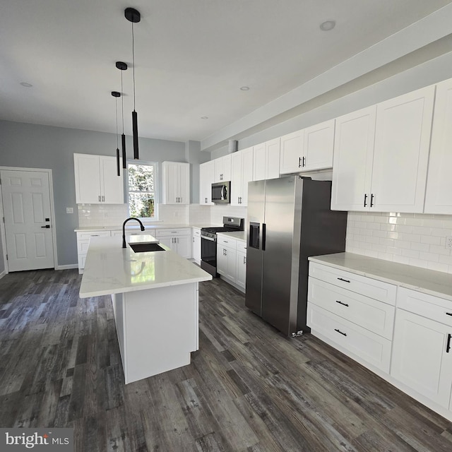 kitchen with a kitchen island with sink, white cabinets, hanging light fixtures, sink, and appliances with stainless steel finishes