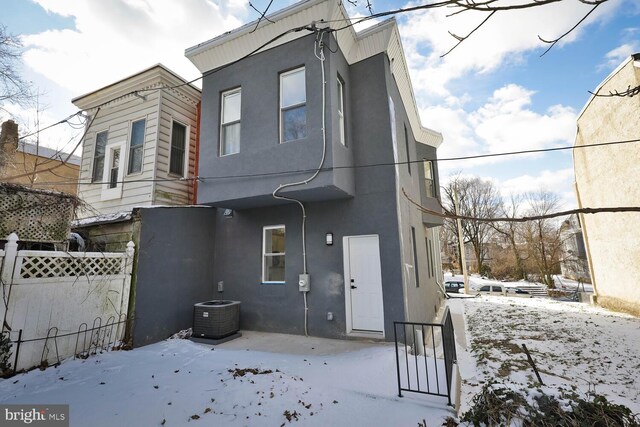 snow covered house with central AC