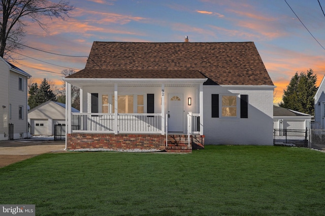 bungalow featuring covered porch and a yard