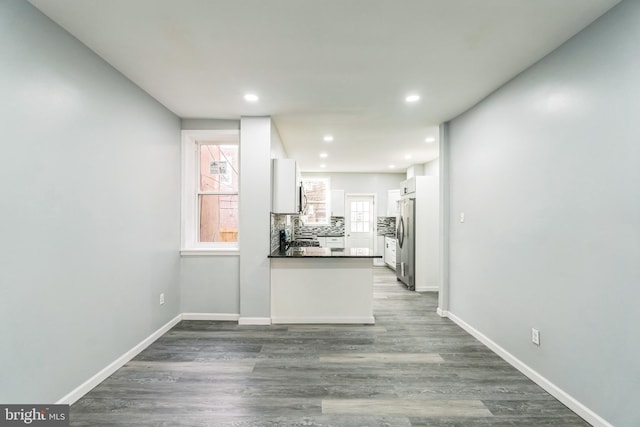 kitchen featuring stainless steel fridge, backsplash, white cabinets, and dark hardwood / wood-style flooring