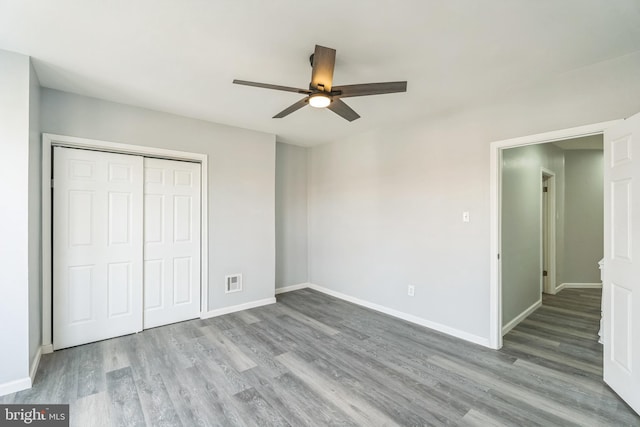 unfurnished bedroom featuring ceiling fan, a closet, and hardwood / wood-style floors