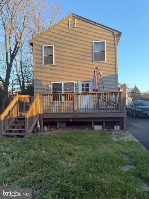 back of house featuring a deck and a yard