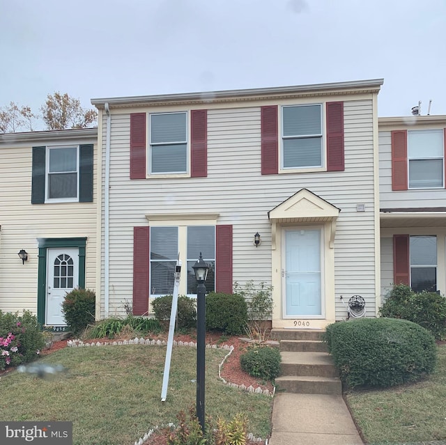 townhome / multi-family property with a front lawn