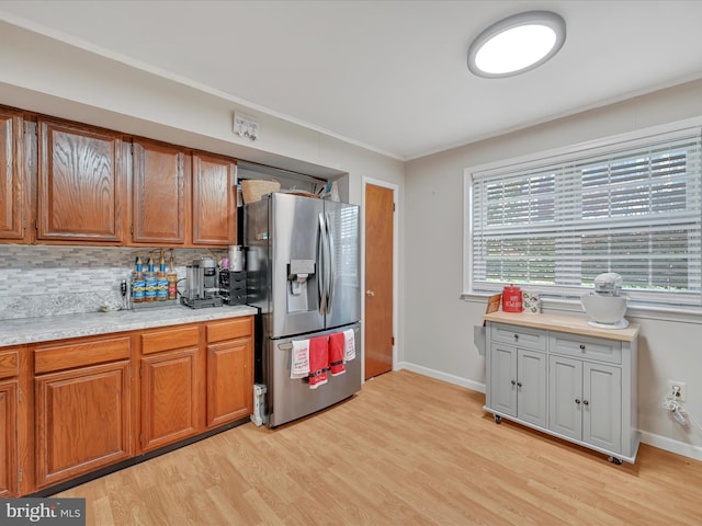 kitchen featuring light hardwood / wood-style floors, stainless steel fridge with ice dispenser, and backsplash