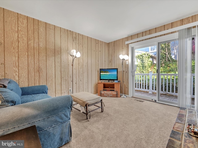 carpeted living room featuring wood walls