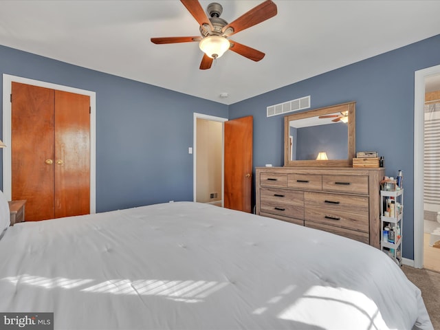 carpeted bedroom with ceiling fan, a closet, and ensuite bath