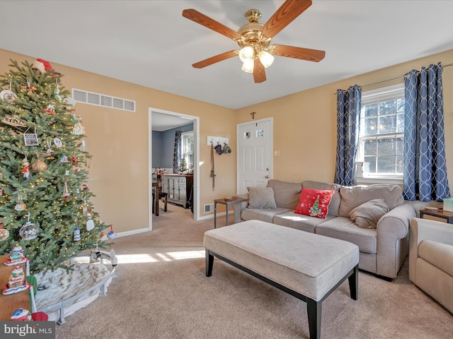 carpeted living room with ceiling fan