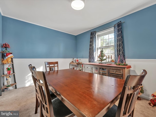 dining room with light carpet and crown molding