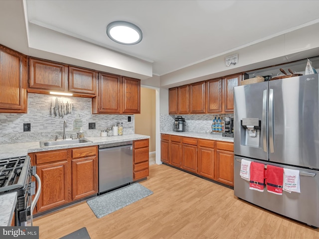 kitchen featuring decorative backsplash, sink, stainless steel appliances, and light hardwood / wood-style flooring