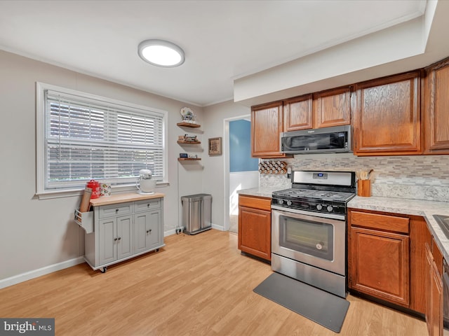 kitchen with decorative backsplash, appliances with stainless steel finishes, and light hardwood / wood-style flooring