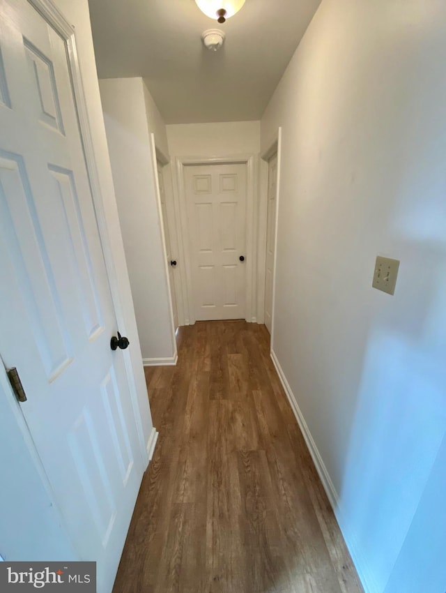 hallway with dark hardwood / wood-style flooring