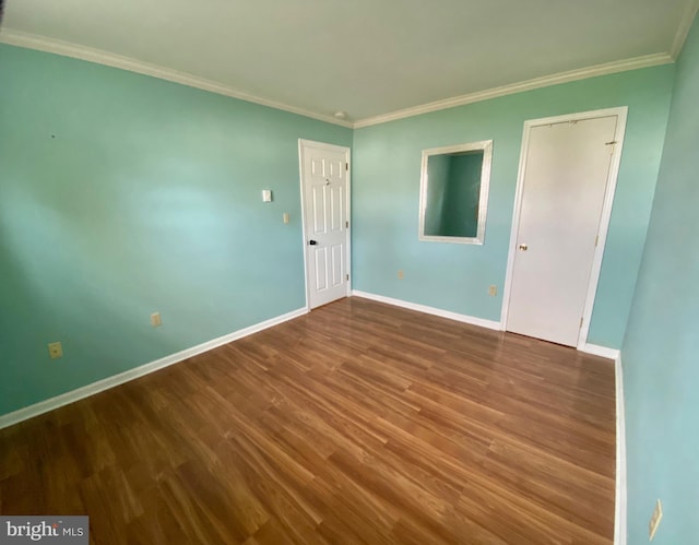 empty room with wood-type flooring and crown molding