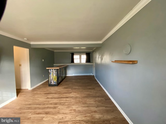 hall featuring a baseboard heating unit, hardwood / wood-style flooring, and crown molding