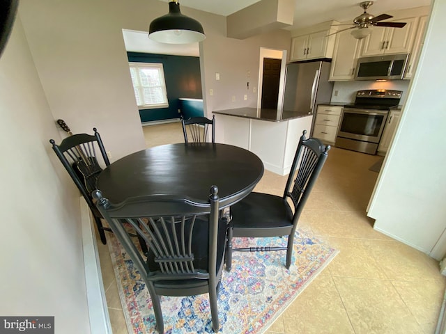 tiled dining space featuring ceiling fan