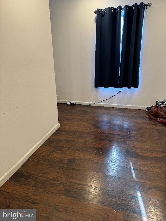 spare room with dark hardwood / wood-style flooring