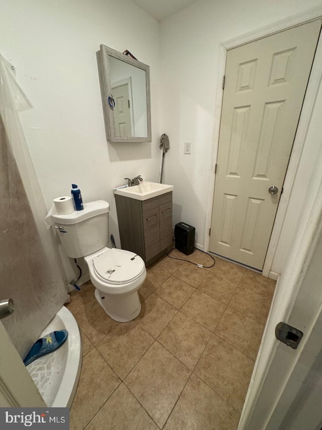 bathroom featuring tile patterned flooring, vanity, and toilet