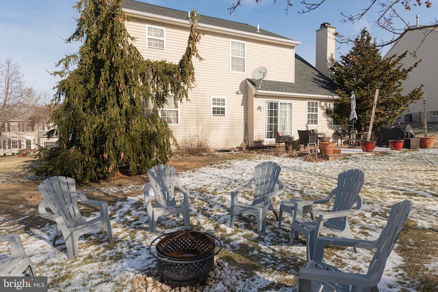 snow covered rear of property featuring an outdoor fire pit