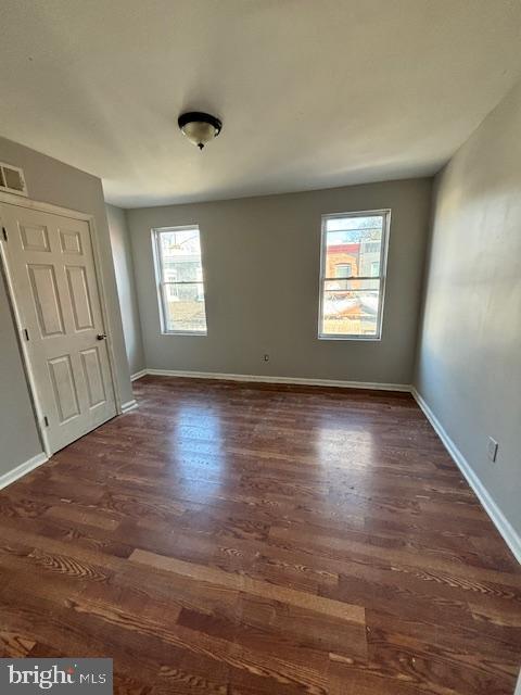 unfurnished room featuring dark wood-type flooring