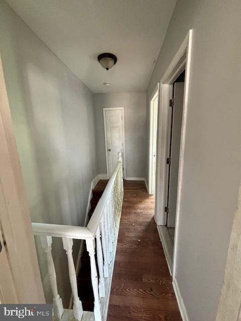 corridor with dark hardwood / wood-style flooring