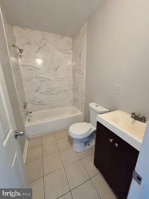 full bathroom featuring tile patterned floors, vanity, tiled shower / bath combo, and toilet