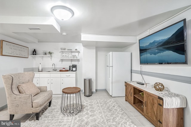 living area featuring light tile patterned flooring and indoor wet bar