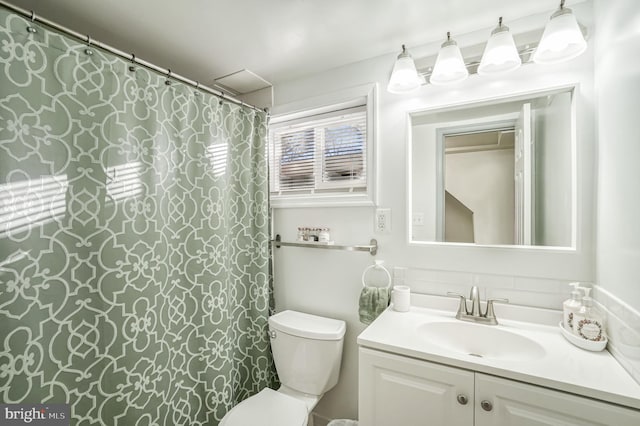 bathroom with backsplash, vanity, and toilet