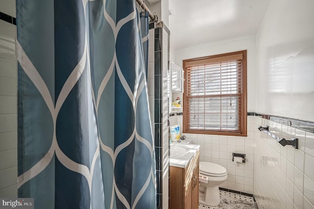 bathroom with tile patterned flooring, vanity, tile walls, and toilet