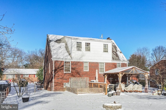 snow covered rear of property featuring a wooden deck