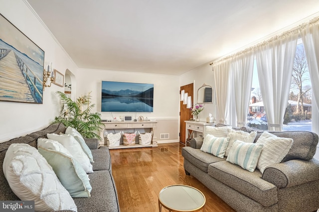 living room with hardwood / wood-style flooring and ornamental molding