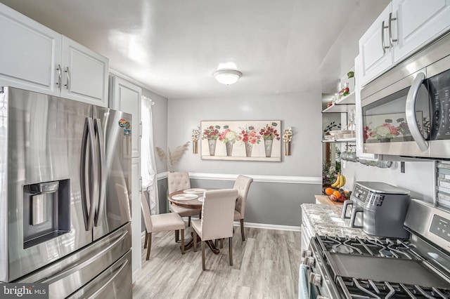 kitchen featuring light hardwood / wood-style flooring, white cabinets, and stainless steel appliances