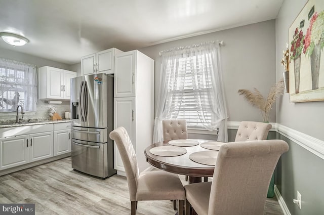 dining area with light hardwood / wood-style flooring and sink