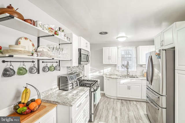 kitchen with backsplash, white cabinetry, sink, and appliances with stainless steel finishes